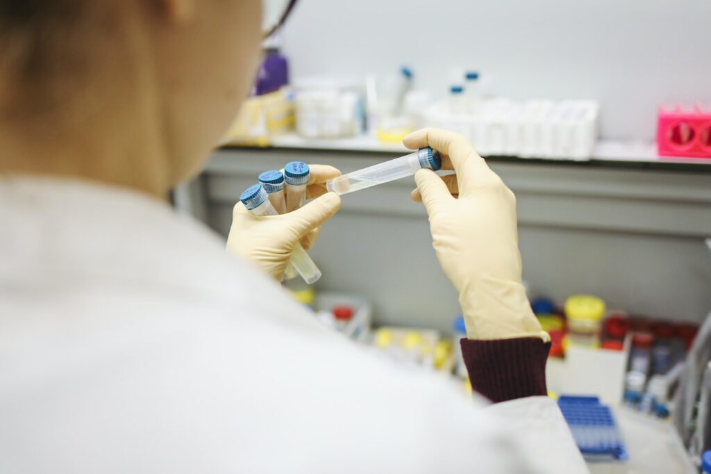 cientista com jaleco branco manipula amostras em laboratório
