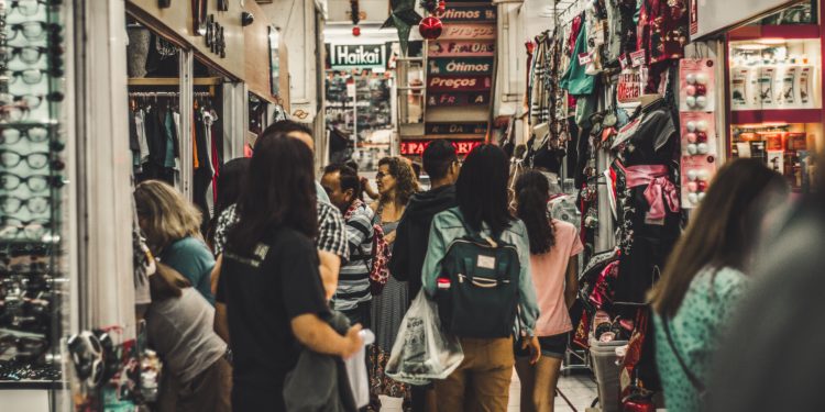 Aglomeração de pessoas em corredor de centro comercial