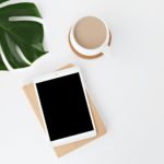 planta, tablet branco e xícara de café sobre superfície branca