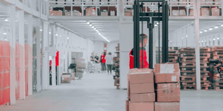 homem transporta caixas em estoque