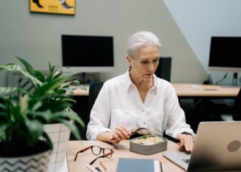 Mulher branca grisalha trabalha em mesa com computador; Mulheres no mercado de trabalho, sobretudo as mais velhas, devem ter apoio das empresas para conciliar a profissão com qualidade de vida, diz pesquisa da FGV