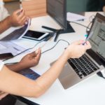 mulher branca aponta para gráfico na tela de computador