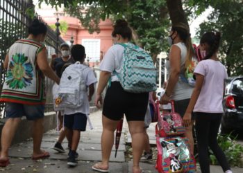 adultas acompanham crianças com uniformes escolares e mochilas a caminho da escola; A política de creches brasileira é um exemplo de ação pública baseada na transversalidade de gênero, pois considera a divisão sexual do trabalho, diz estudo da FGV.