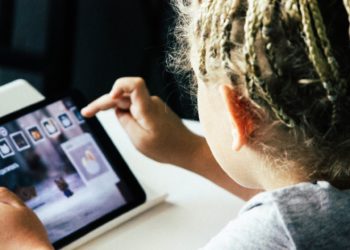 criança manuseia tablet