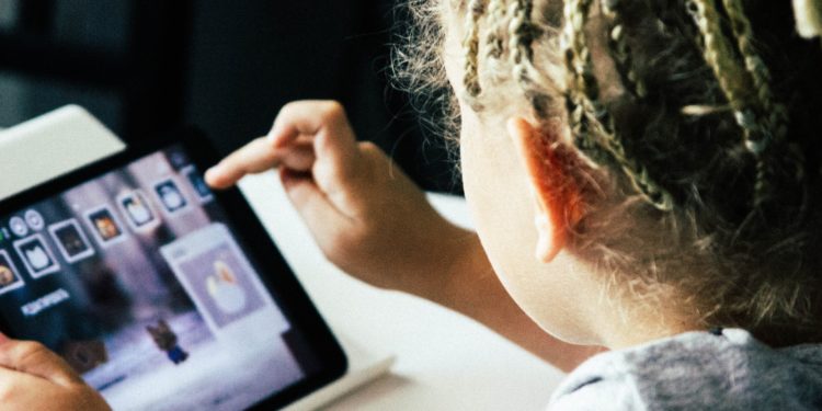 criança manuseia tablet