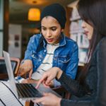 Duas Mulheres Olhando E Apontando Para O Laptop
