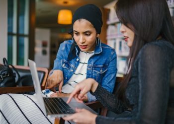 Duas Mulheres Olhando E Apontando Para O Laptop