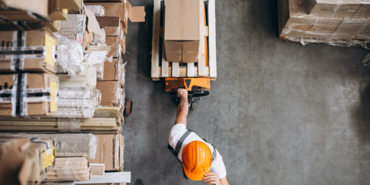 Trabalhador organiza caixas com suprimentos em depósito