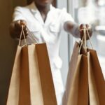 consultora de venda segura sacolas de compras em direção à câmera