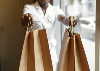 consultora de venda segura sacolas de compras em direção à câmera