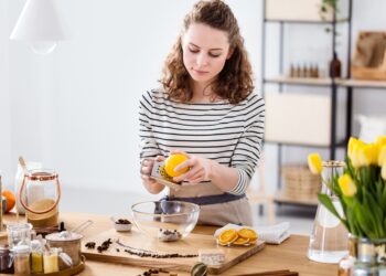 Pessoa preparando cosméticos naturais em casa com ingredientes simples, representando o consumo consciente e bem-estar.