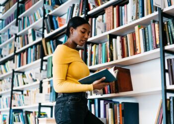 moça na frente de uma estante com livros