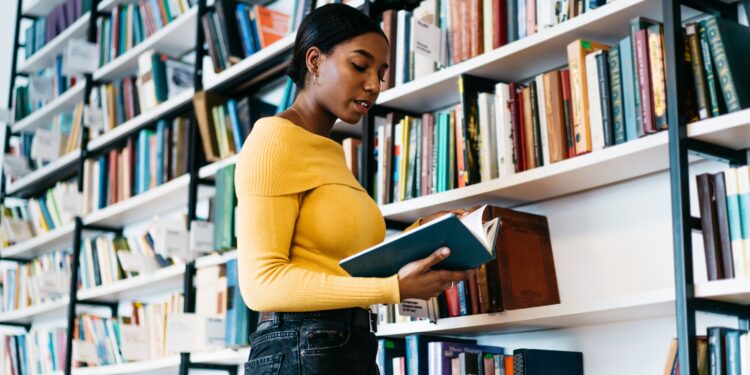 moça na frente de uma estante com livros