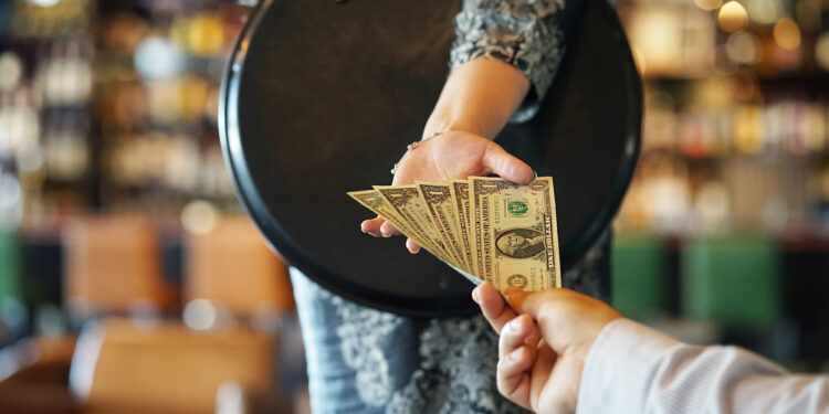 Pessoa em situação pública demonstrando constrangimento após comportamento inadequado de alguém do mesmo grupo e tomando uma atitude sobre isso
