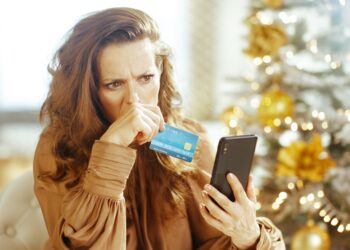 Pessoa analisando contas e cartão de crédito em um contexto de preocupação financeira