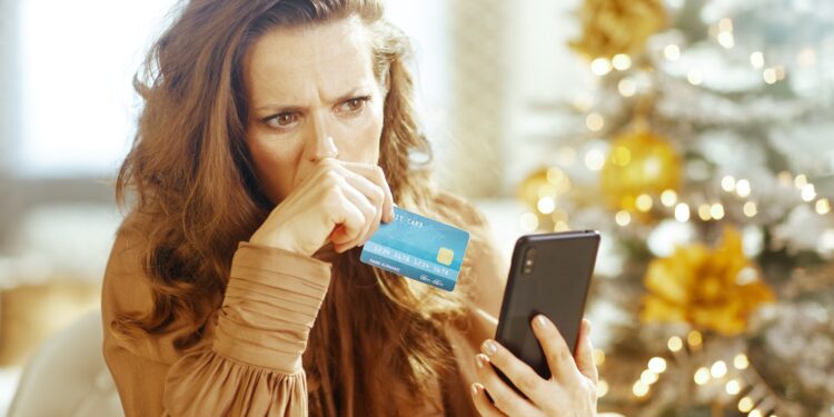 Pessoa analisando contas e cartão de crédito em um contexto de preocupação financeira