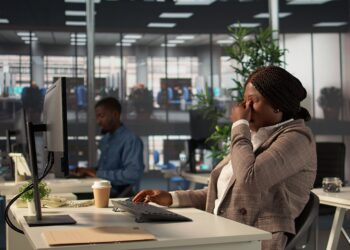 ambiente de trabalho corporativo com pessoas em situação de estresse e apoio entre colegas