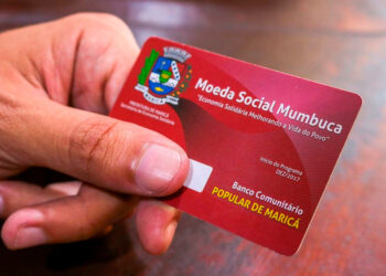 Moradores utilizando moeda digital em comércios locais mostrando como a transferência de renda fortalece a economia local.