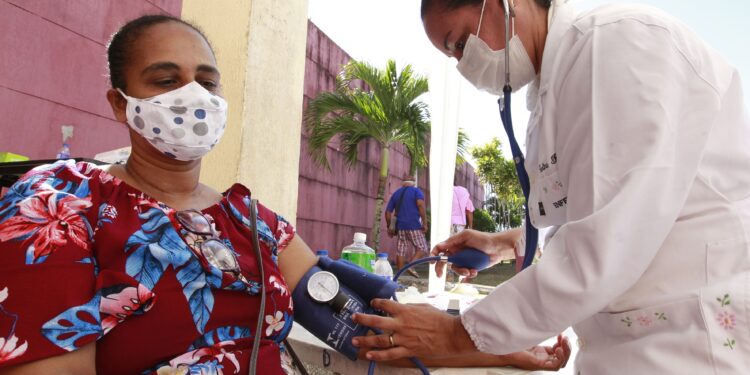 Profissional de saúde realizando atendimento em unidade básica após a saída dos médicos cubanos em município vulnerável do Brasil.
