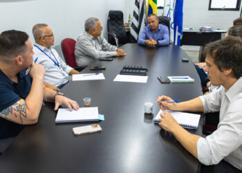 Servidores públicos discutindo estratégias de resistência a pressões antidemocráticas em ambiente institucional