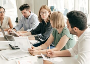 Liderança estratégica em equipes com executivos reunidos discutindo estratégias e decisões conjuntas
